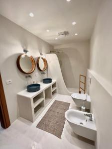 a bathroom with two sinks and a mirror at White Pearl Villa in Dhërmi