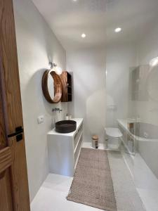 ein Badezimmer mit einem Waschbecken, einem WC und einem Spiegel in der Unterkunft White Pearl Villa in Dhërmi