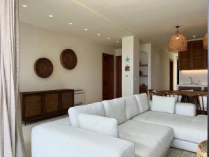 a living room with a white couch and a table at White Pearl Villa in Dhërmi