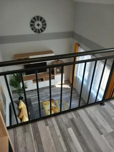 a staircase with black railing and a clock on the wall at Gemini Apartman in Esztergom