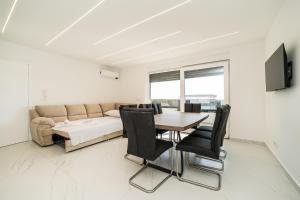 ein Wohnzimmer mit einem Tisch und einem Sofa in der Unterkunft Apartments Ante in Novalja