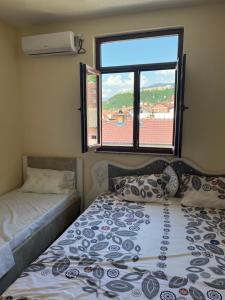 a small bedroom with a bed and a window at Center Side in Prizren