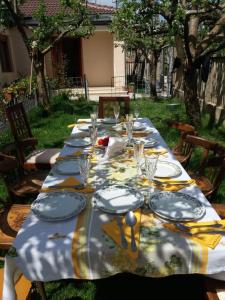 einen langen Tisch mit Tellern und Gläsern darauf in der Unterkunft Kristina Mitllari 1 in Pogradec