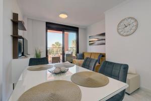 salon ze stołem, krzesłami i zegarem w obiekcie Peaceful & Elegant Getaway home w mieście Mijas Costa