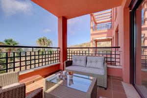 balkon z kanapą i szklanym stołem w obiekcie Peaceful & Elegant Getaway home w mieście Mijas Costa
