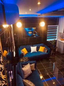 uma sala de estar com sofás azuis e uma parede em Azure Gold Apartment em Senglea