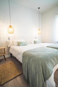 two large beds in a bedroom with two lamps at Plaza Cuatro in Santander