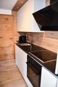 a kitchen with a sink and a stove at Astn Hütten - Königsleiten - Ferienwohnungen in Königsleiten