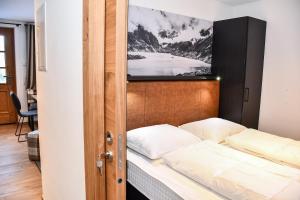 - une chambre avec un lit et une télévision murale dans l'établissement Astn Hütten - Königsleiten - Ferienwohnungen, à Königsleiten