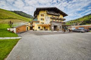 ein großes gelbes Gebäude an der Seite eines Hügels in der Unterkunft Hotel Gungau in Saalbach-Hinterglemm