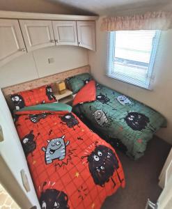 a bedroom with two beds with hello kitty comforters at Wonderful 2 bedroom mobile home in Aberystwyth