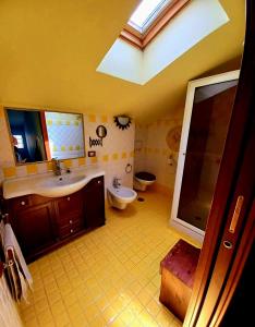 a bathroom with a sink and a toilet and a skylight at La Rosa dei Venti Guest House in Pontecagnano