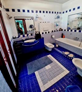 a blue and white bathroom with a tub and a sink at La Rosa dei Venti Guest House in Pontecagnano