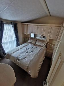 Un dormitorio con una cama grande y una ventana en Wonderful 2 bedroom mobile home en Aberystwyth