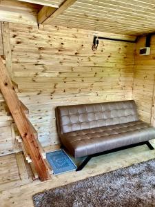 Mtirala Skhivi Cottage في باتومي: مقعد من الجلد يجلس في غرفة خشبية