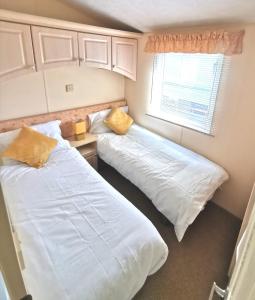 1 dormitorio con 2 camas y ventana en Wonderful 2 bedroom mobile home en Aberystwyth