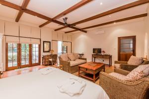 a bedroom with a bed and a living room at Gable Manor in Franschhoek
