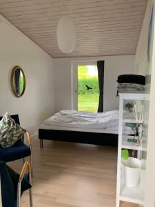 1 dormitorio con cama y ventana en Tusindfrugt B&B, en Store Heddinge