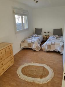 a bedroom with two beds and a rug on the floor at Appartement Briançon T 4 in Briançon