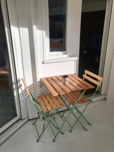 a wooden chair sitting on a porch next to a window at Appartement Briançon T 4 in Briançon