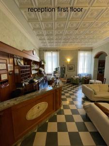 a large room with a checkerboard floor and a lobby at Hotel Giglio in Florence