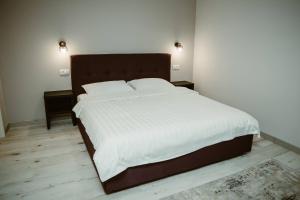 a bedroom with a large bed with white sheets and pillows at ARINI WHITE HOUSE in Sibiu