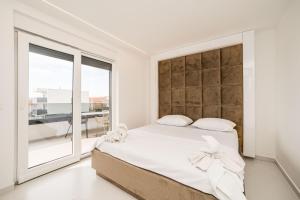 ein Schlafzimmer mit einem großen Bett und einem großen Fenster in der Unterkunft Apartments Ante in Novalja
