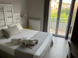 1 dormitorio con 1 cama blanca grande con 2 bolsas. en B&B L’ALTRAMURGIA, en Cassano delle Murge