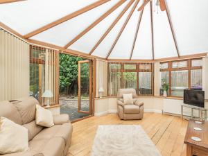 a living room with a couch and chairs and windows at Dovedale Cottage in Coningsby