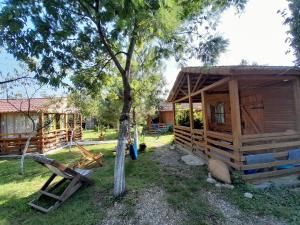 a wooden cabin with a tree in the yard at Tiny houses Genacvale in Martvili