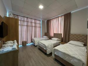 Una habitación de hotel con dos camas y un televisor. en Hotel Princ, en Shkodër
