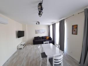 uma sala de estar com uma mesa branca e um sofá em Апартаменти Жилищна сграда Орех em Varna