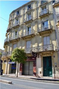 a large building with balconies on a city street at Appartement 105 m2 rue Foch Arc de Triomphe hyper centre Montpellier in Montpellier