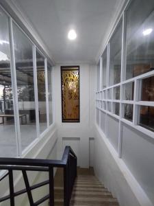 a hallway with white walls and a door with windows at Saira Hotel dan Homestay Syariah in Sleman