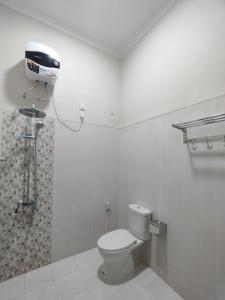 a bathroom with a toilet and a shower at Saira Hotel dan Homestay Syariah in Sleman