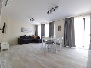 uma sala de estar com uma mesa e um sofá em Апартаменти Жилищна сграда Орех em Varna