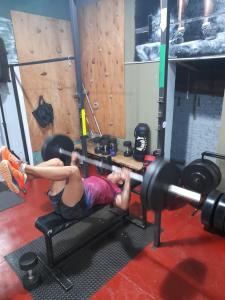 a woman laying on a barbell in a gym at HOSTEL DEL HERRERO in Apóstoles