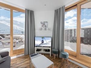 un soggiorno con TV e ampie finestre di Appartement Val Thorens, 3 pièces, 6 personnes - FR-1-640-23 a Val Thorens