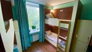 a small room with bunk beds and a window at Golden Square in Almaty