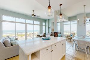 a kitchen with a large island in a room with windows at Emerald By the Sea 1214 Sea for Miles in Galveston