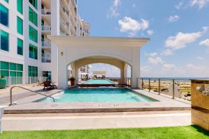 a swimming pool in front of a building at Emerald By the Sea 1214 Sea for Miles in Galveston