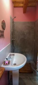 Baño con lavabo blanco y pared rosa en Can Parròquia, en Sant Esteve de Palautordera