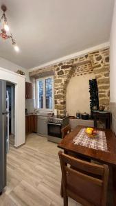 una cucina con tavolo e una cucina con parete in pietra di Royal House a Kotor (Cattaro)