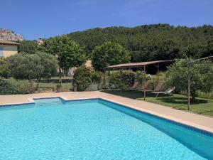 a large swimming pool in a yard with two chairs at Les Grandes Terres - Gîtes & SPA in Mérindol