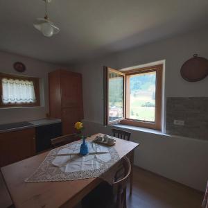 a kitchen with a table and two windows at Al Doss in Rabbi