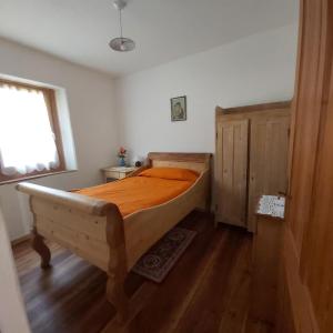 a bedroom with a bed with an orange comforter at Al Doss in Rabbi