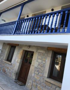 Casa con balcón azul y 2 puertas en Tela Marinera, en Lastres