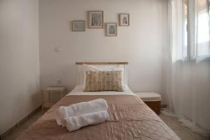 a bedroom with a bed with a pillow and a window at Η μονοκατοικία της Χαράς. in Kalamáki