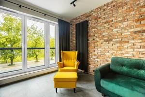 sala de estar con silla amarilla y sofá verde en Stunning loft-style apartment en Varsovia