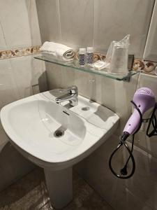 a white bathroom sink with a blow dryer on it at Hotel Wellamar in Sant Feliu de Guíxols +68 photos